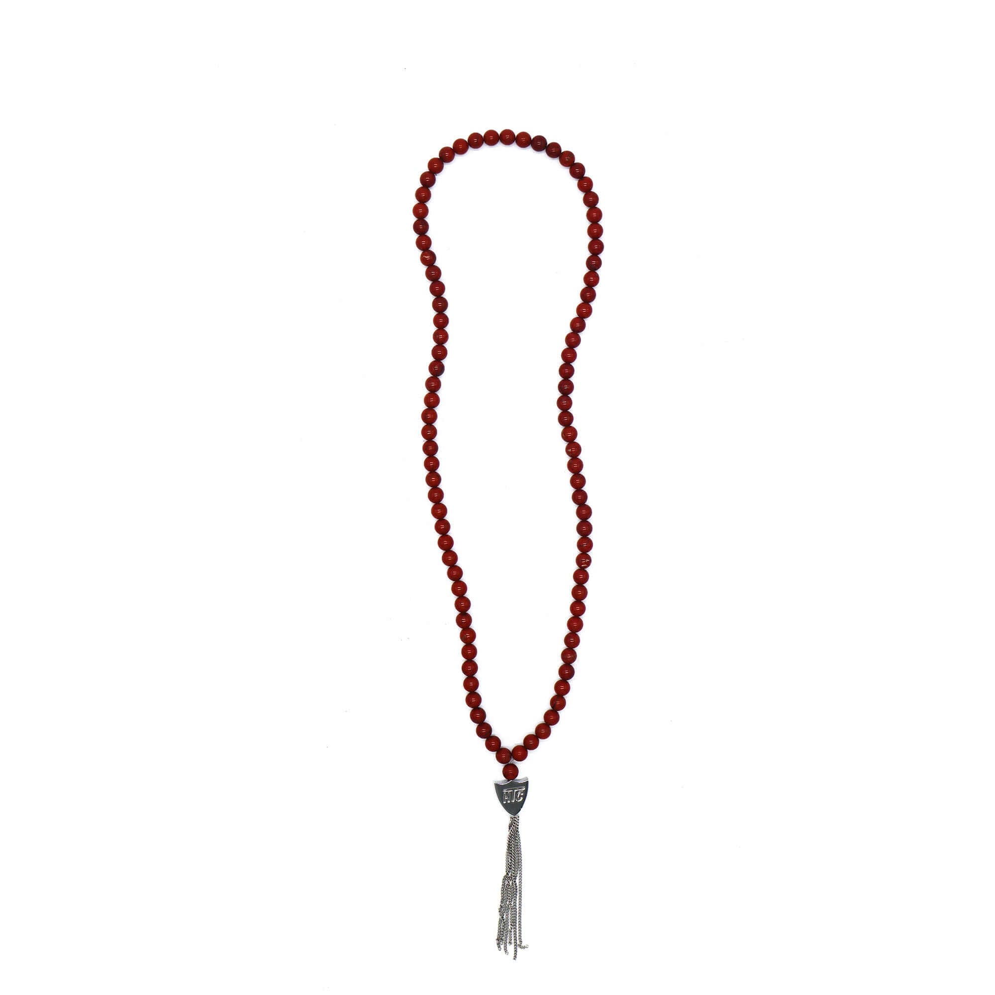 htc los angeles MYSTERY SHIELD NECKLACE RED Red necklace featuring a blend of textile, glass, and metal materials, with a metal HTC logo detail. Hollywood Trading Company