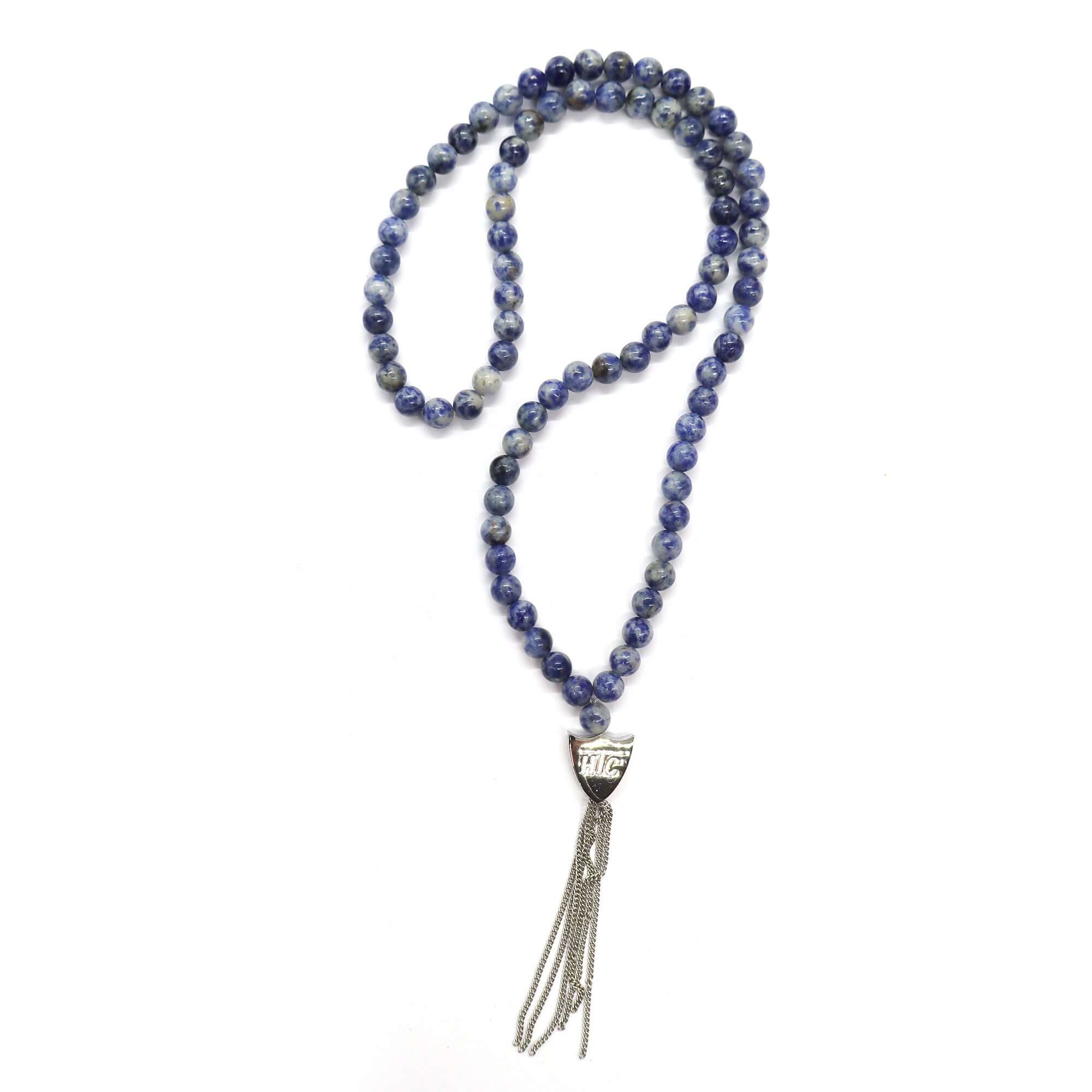 htc los angeles MYSTERY SHIELD NECKLACE SODALITE Sodalite necklace featuring a blend of textile, glass, and metal materials, with a metal HTC logo detail. Hollywood Trading Company