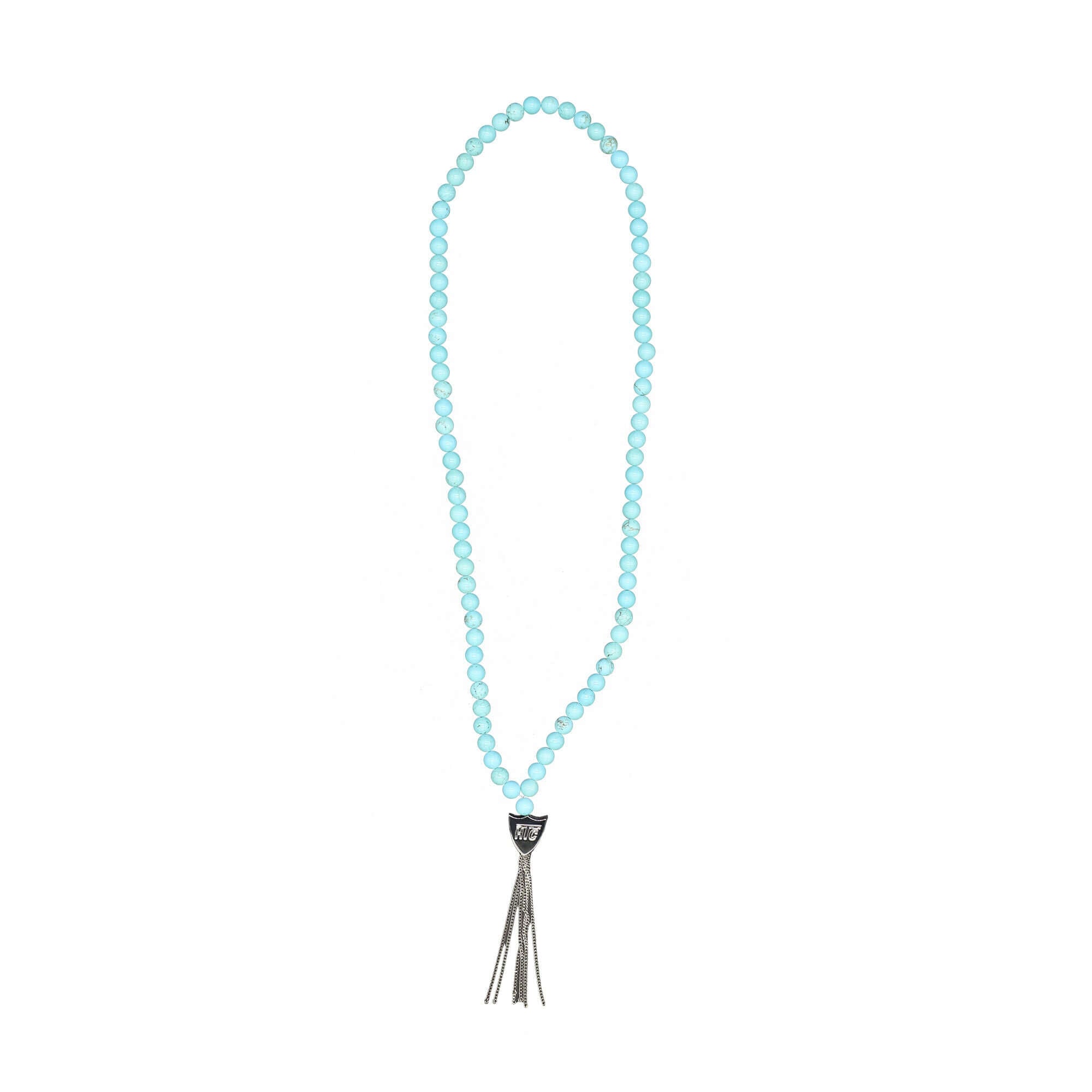 htc los angeles MYSTERY SHIELD NECKLACE TURQUOISE Turquoise necklace featuring a blend of textile, glass, and metal materials, with a metal HTC logo detail. Hollywood Trading Company