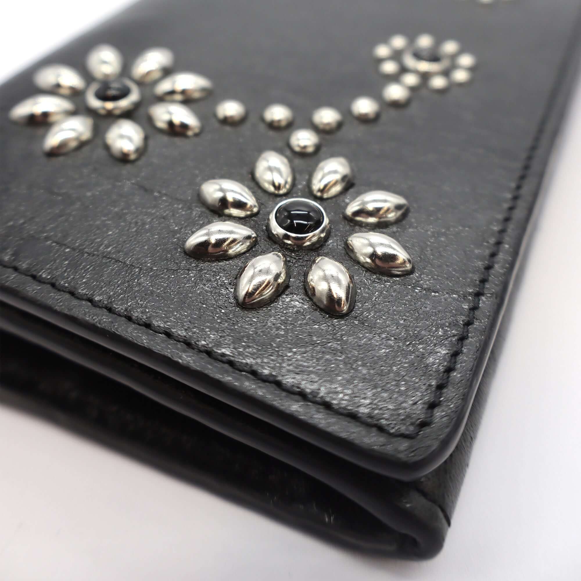 htc los angeles NANCY LONG WALLET BLACK Long wallet in Black, featuring a button closure. Designed with compartments for cards and coins, with flower studded details on the exterior. Crafted in Italy, 100% cow leather. Hollywood Trading Company