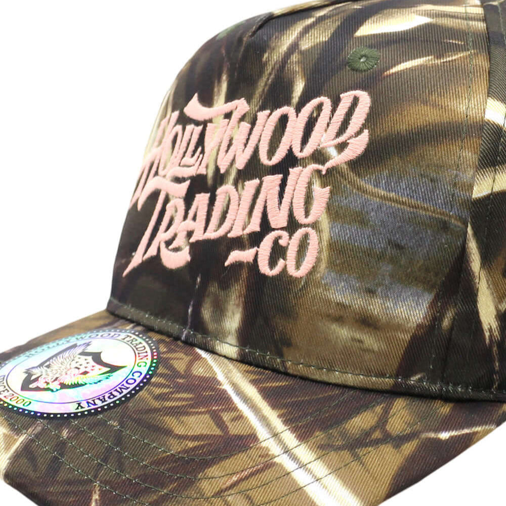 Hollywood Trading Company HOLLYWOOD T.C. CAMO CAP HOLLYWOOD T.C. CAMO CAP Baseball cap with preformed peak, round crown with eyelets, Hollywood TC embroidered on the front, adjustable strap on the back. One size fits all. 100% cotton. Hollywood Trading Co