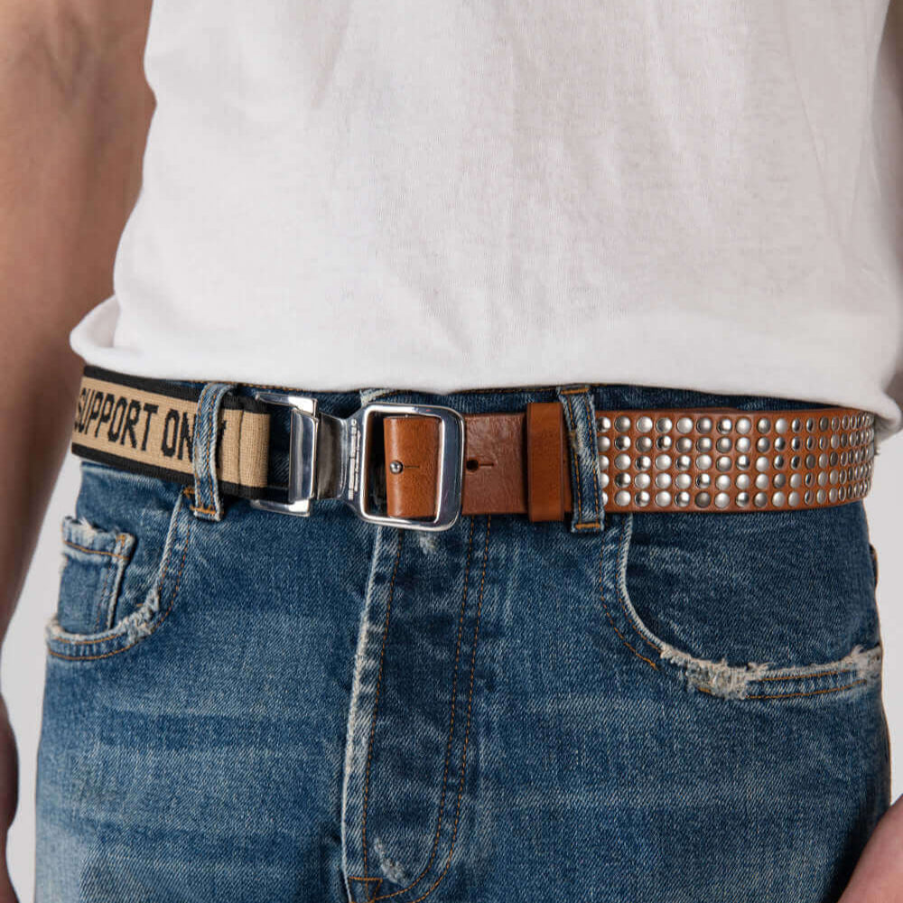 Hollywood Trading Company 5.000 FASTEN BELT 5.000 FASTEN BELT Studded leather belt & elastic band. Tension buckle closure. Height: 3,5 cm. Composition: 50% Leather 50% Polyester. Made in Italy BELTS Hollywood Trading Company Hollywood Trading Company