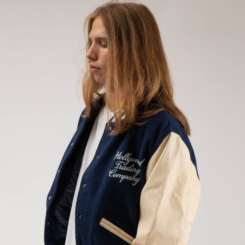 Hollywood Trading Company COLLEGE - EMBROIDERY MAN COLLEGE - EMBROIDERY MAN Varsity wool & leather bomber jacket. Front button closure, ribbed collar, cuffs and hem. Embroidered details. Two side pockets. Main body composition: 70% Wool, 30% Acrylic; slee