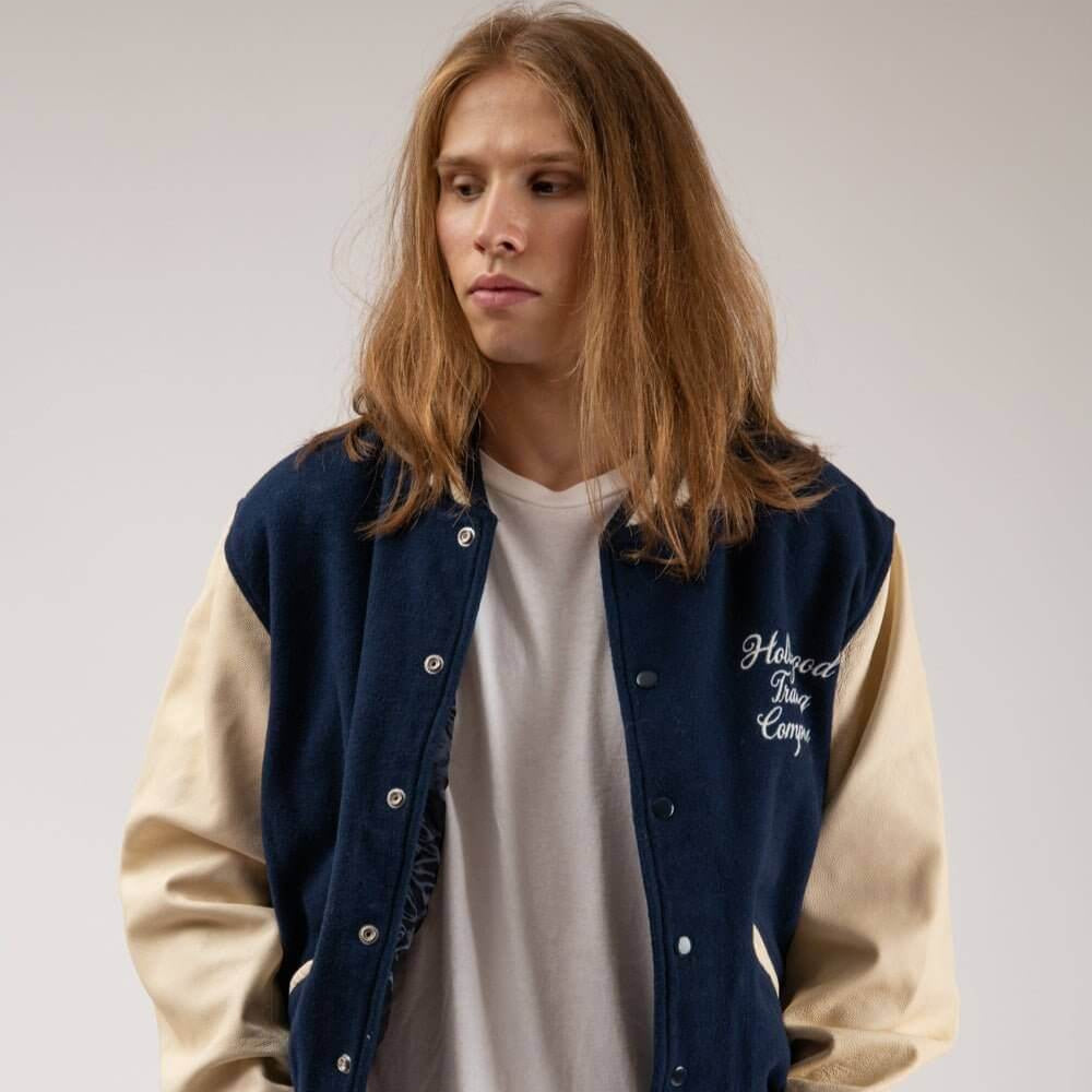 Hollywood Trading Company COLLEGE - EMBROIDERY MAN COLLEGE - EMBROIDERY MAN Varsity wool & leather bomber jacket. Front button closure, ribbed collar, cuffs and hem. Embroidered details. Two side pockets. Main body composition: 70% Wool, 30% Acrylic; slee
