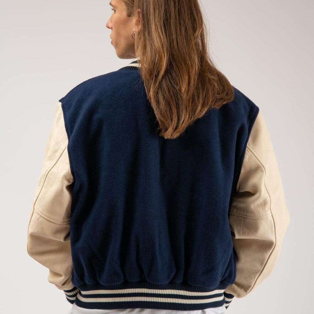 Hollywood Trading Company COLLEGE - EMBROIDERY MAN COLLEGE - EMBROIDERY MAN Varsity wool & leather bomber jacket. Front button closure, ribbed collar, cuffs and hem. Embroidered details. Two side pockets. Main body composition: 70% Wool, 30% Acrylic; slee