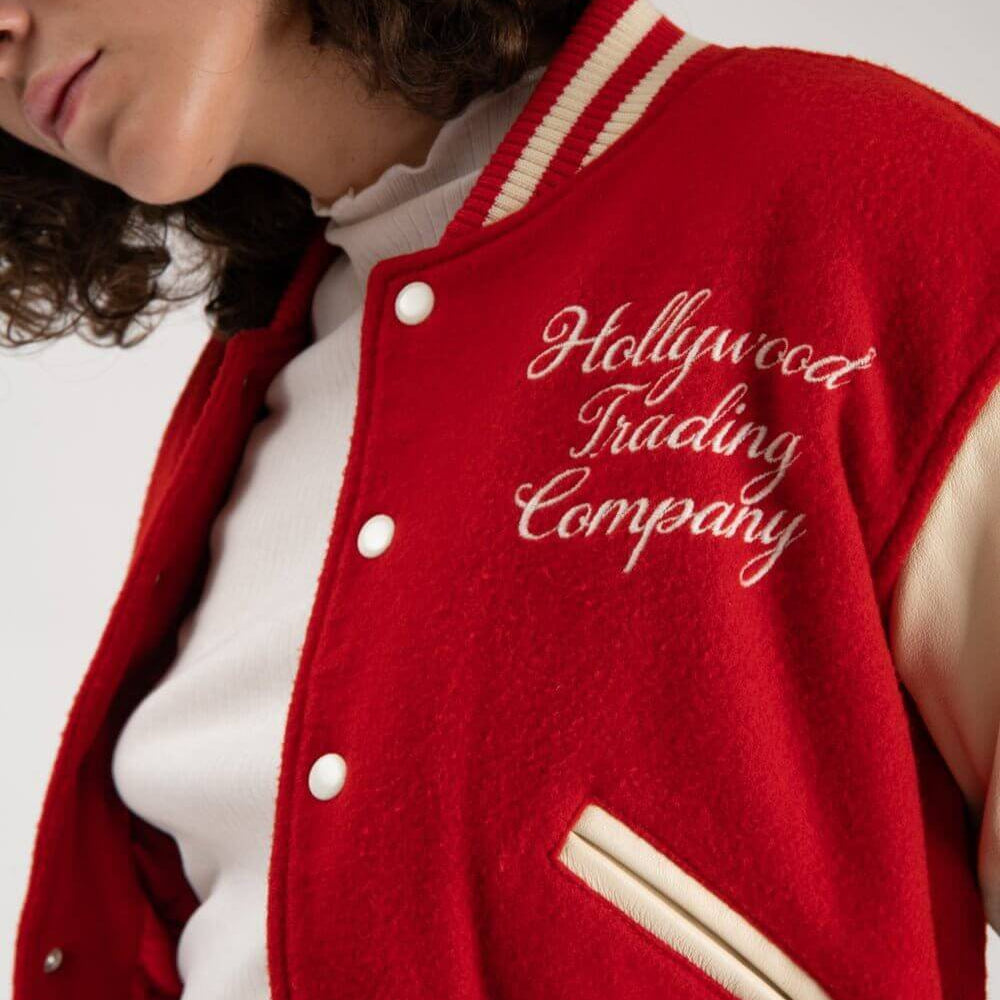Hollywood Trading Company COLLEGE - EMBROIDERY WOMAN COLLEGE - EMBROIDERY WOMAN Varsity wool & leather bomber jacket. Front button closure, ribbed collar, cuffs and hem. Embroidered details. Two side pockets. Main body composition: 70% Wool, 30% Acrylic;