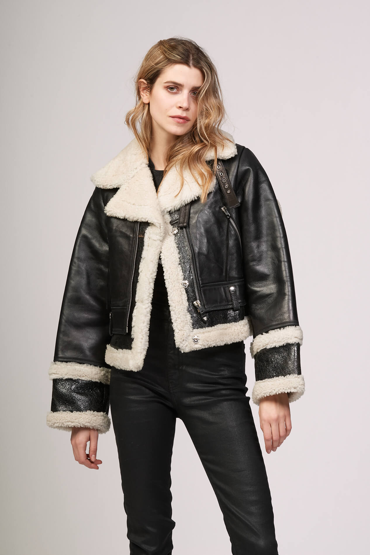 LOU SHEARLING Black leather jacket. Lining, contour and lapels in white shearling. Frontal buttons. Wrist bands with buttons. 2 side pockets. 100% sheepskin. Made in Italy. HTC LOS ANGELES