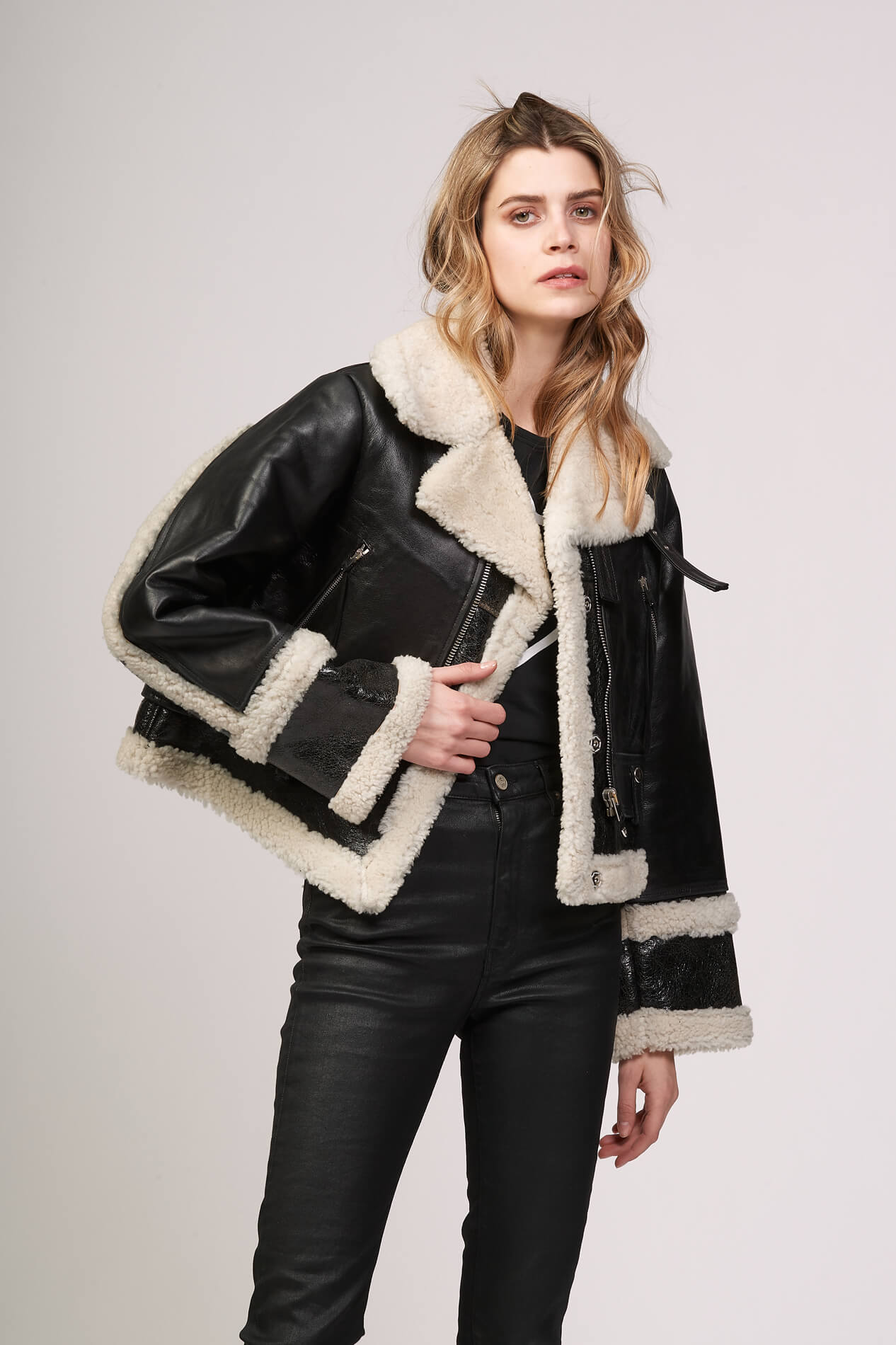 LOU SHEARLING Black leather jacket. Lining, contour and lapels in white shearling. Frontal buttons. Wrist bands with buttons. 2 side pockets. 100% sheepskin. Made in Italy. HTC LOS ANGELES